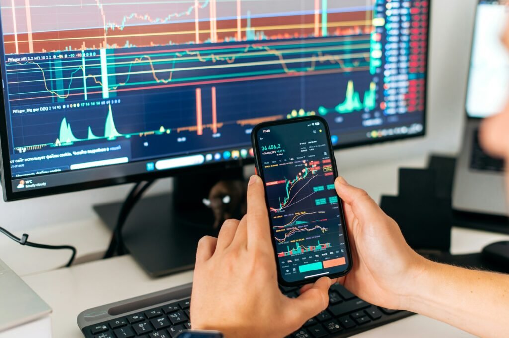 Online trading. Close-up of a smartphone in male hands, with trading data index chart graph on the