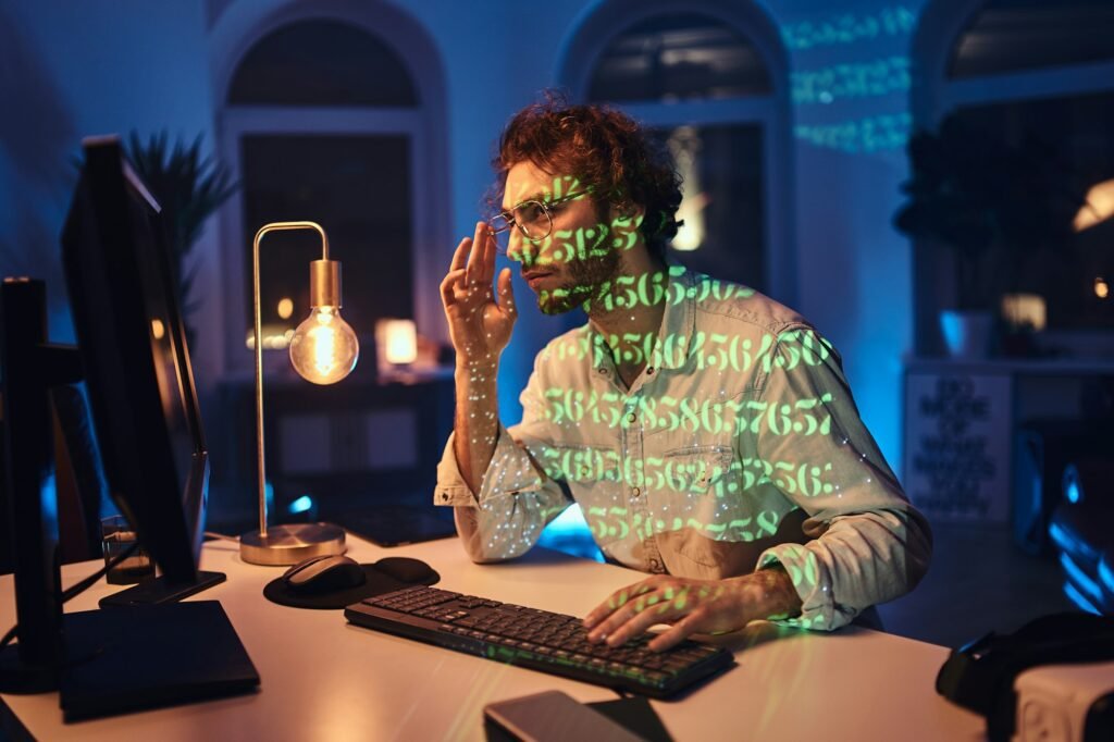 Professional programmer doing his job on computer in dark office