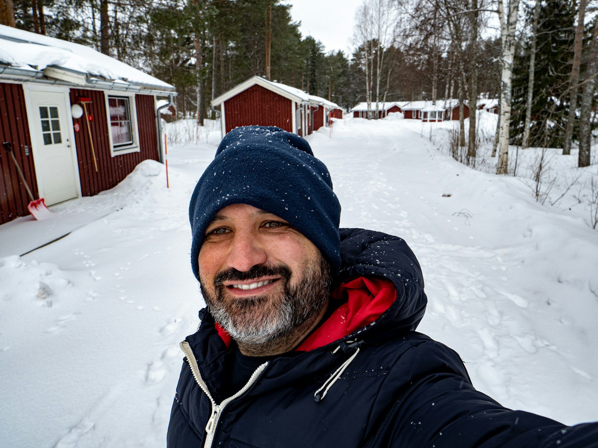 Pov of a man in winter clothes taking a smiling selfie in a snowy landscape in Sweden.
